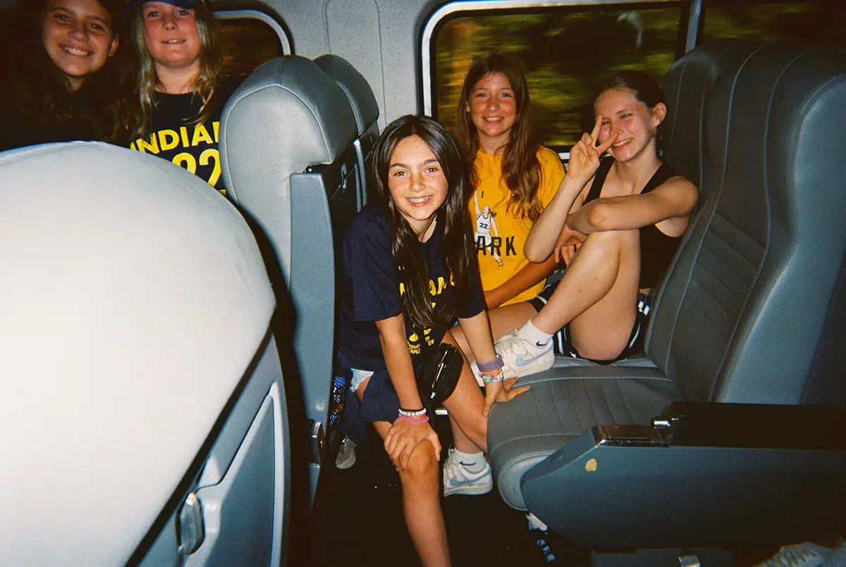 several young girls sitting on train seats