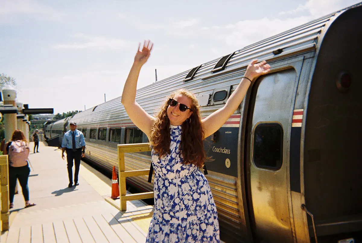 girl waving hands before getting on train